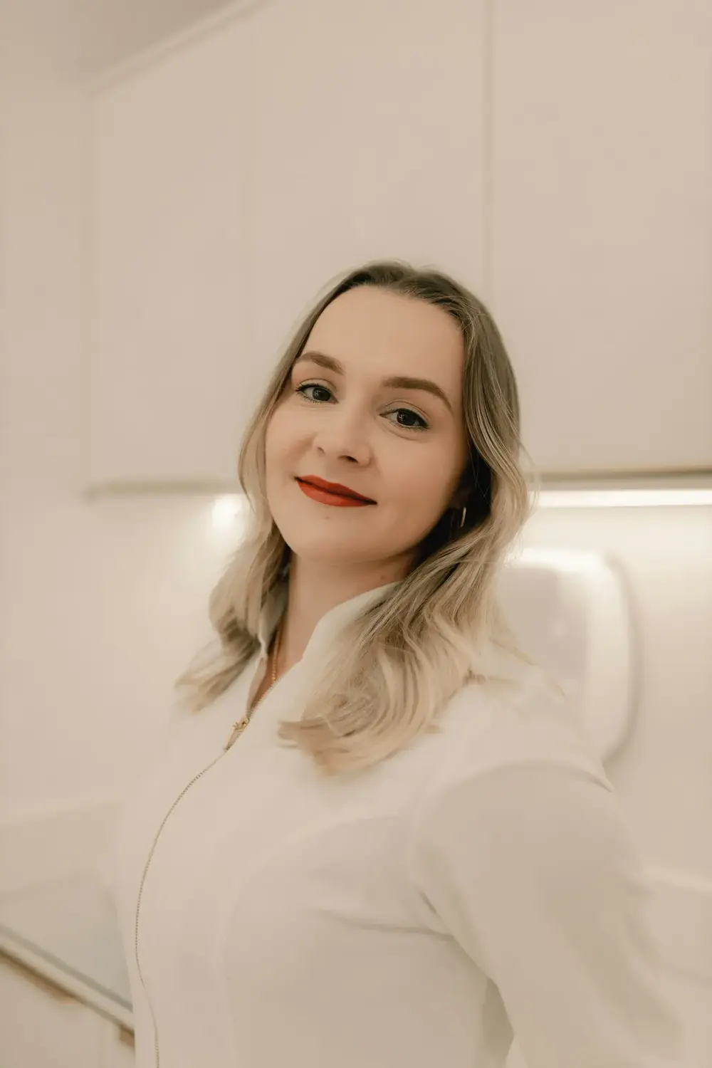 Dra. Lívia Hoffmann de jaleco branco na sala do estúdio
